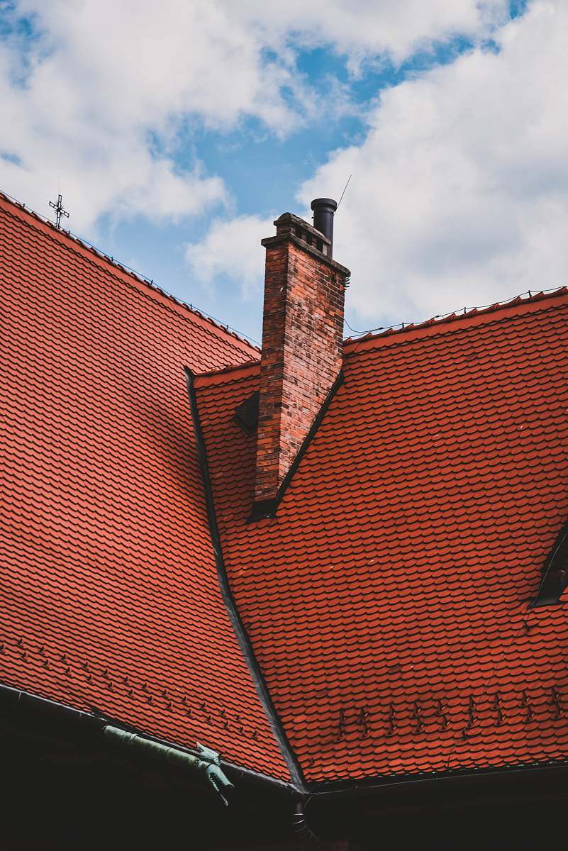 tile roof orange roof view under blue and white skies yellow